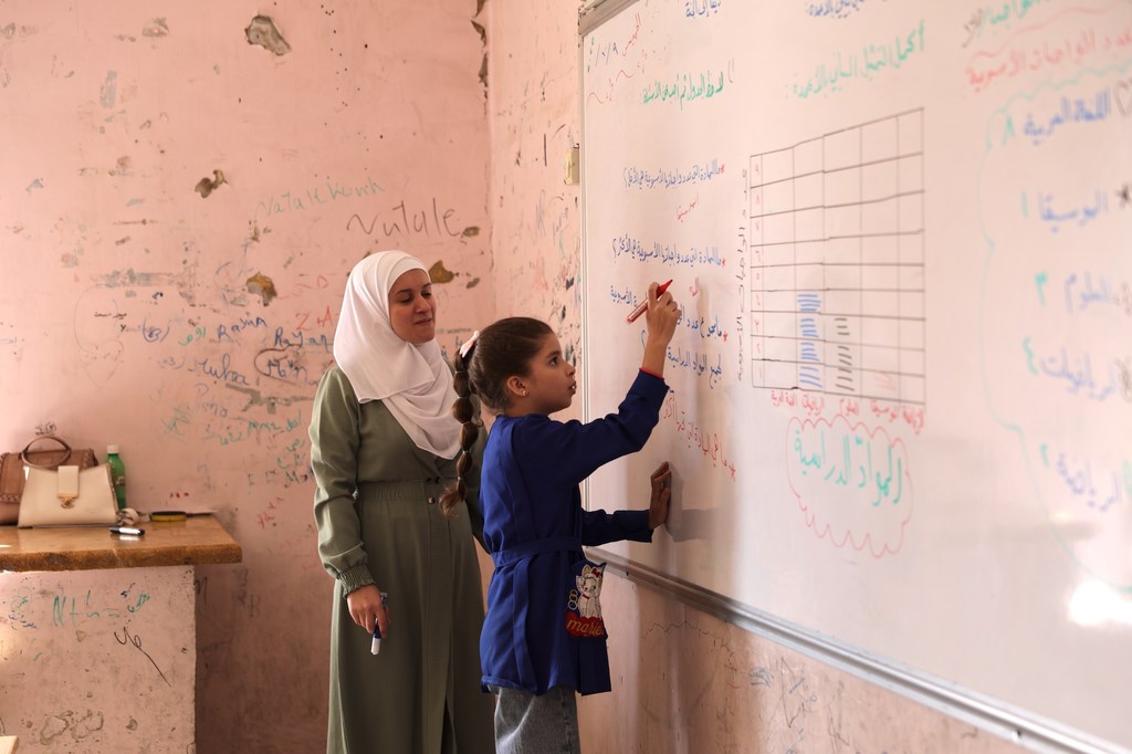 在阿勒颇农村地区，一名九岁女孩正在一所由联合国儿童基金会修缮的学校就读，该校在冲突期间曾遭受严重破坏。
